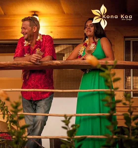 A couple relaxing with a glass of champagne on a bungalow terrace at Kona Koa Eco Lodge.
