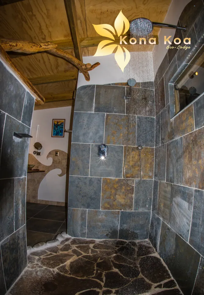 Inside the shower of the Haka Nini bungalow, slate walls and pebble floor.