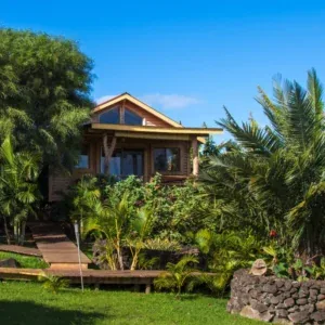 Wooden Haka Honu bungalow surrounded by tropical plants on Easter Island.