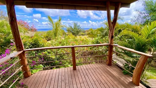 Wooden terrace of the Haka Honu bungalow, overlooking the tropical garden and the Pacific.