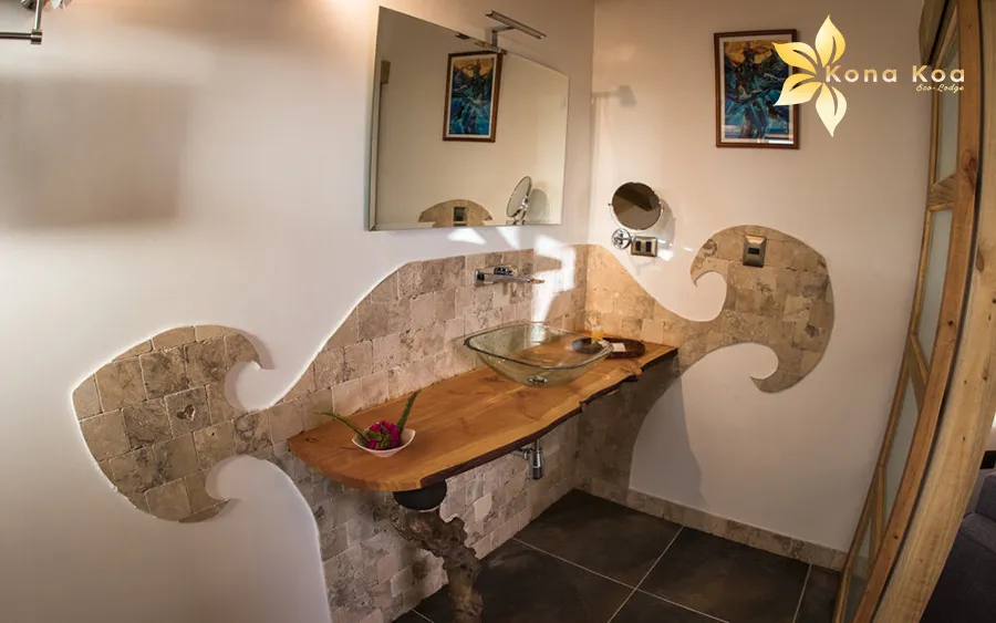 Bathroom of the Haka Nini bungalow with a glass basin on a raw wood unit.