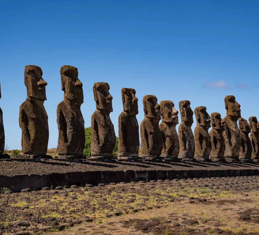 The fifteen moai of Ahu Tongariki lined up on their platform, seen head-on under a blue sky.