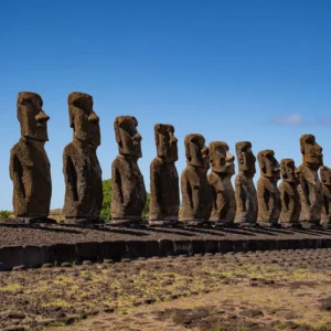 The fifteen moai of Ahu Tongariki lined up on their platform, seen head-on under a blue sky.