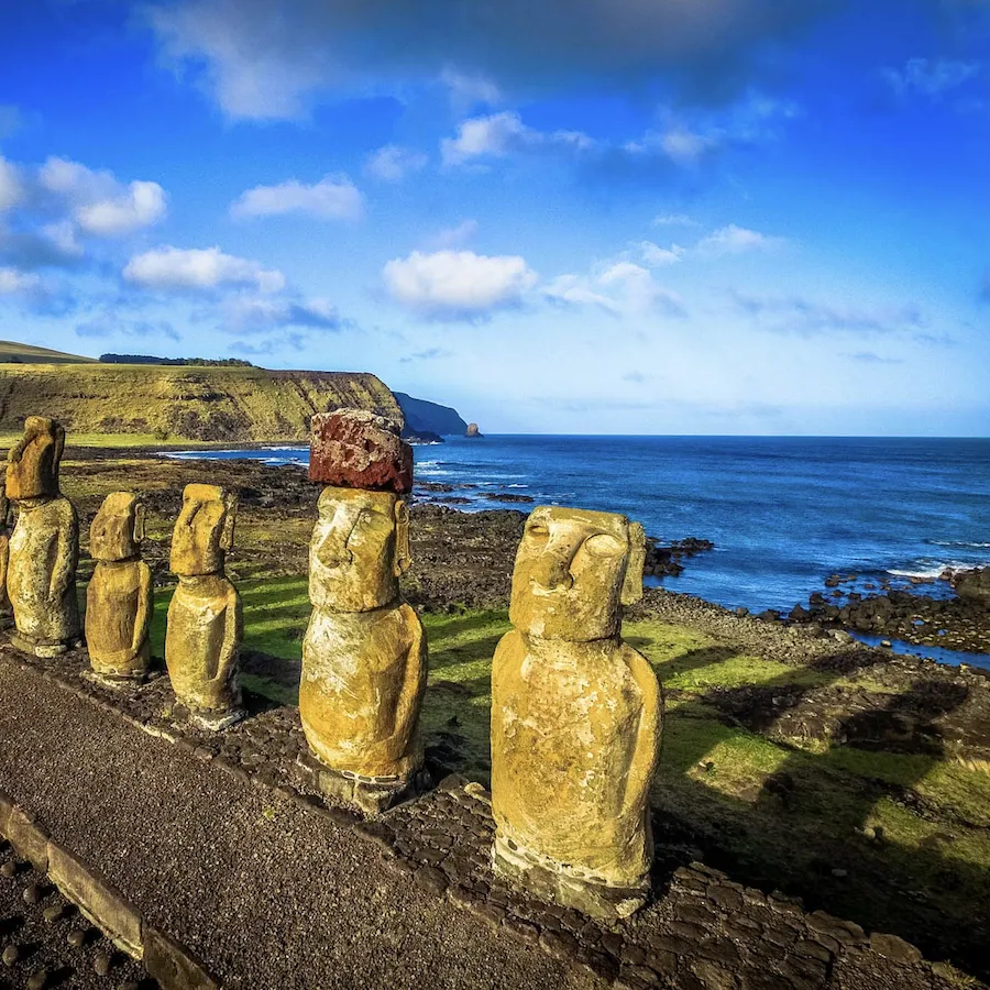 The moai of Ahu Tongariki on the Rapa Nui coast, with the Pacific and the Poike cliff behind.